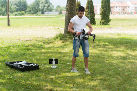 Young Engineer Man Prepares a Drone to Flight in Park
