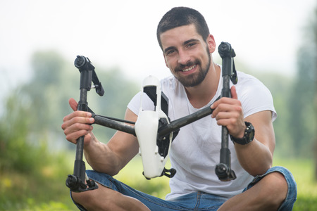 Young Engineer Man Prepares a Drone to Flight in Parkの写真素材