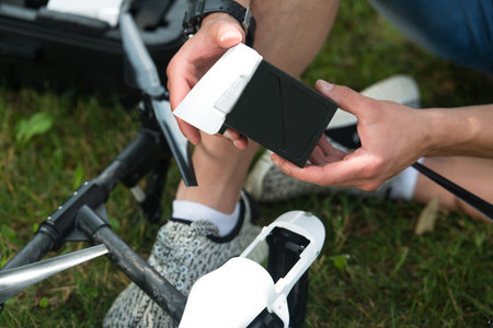 Closeup of Young Engineer Man Checking the Battery of Uav Drone With Hand Tool in Park