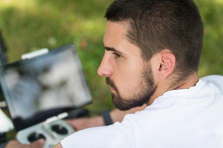 Young Engineer With Remote Control Preparing to Flying a Drone in Park