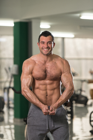 Portrait Of A Young Physically Fit Hairy Man Showing His Well Trained Body - Muscular Athletic Bodybuilder Fitness Model Posing After Exercisesの写真素材