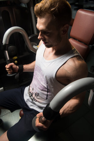 Handsome Muscular Fitness Bodybuilder In Undershirt Doing Heavy Weight Exercise For Biceps On...