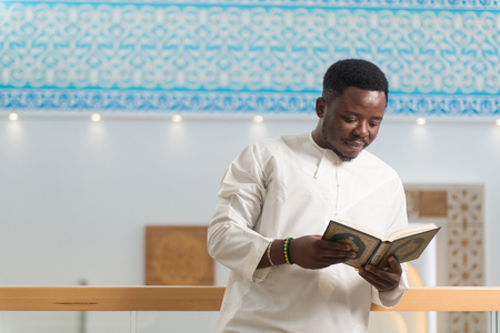 Black African Muslim Man Reading Holy Islamic Book Koranの写真素材