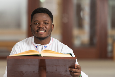 Portrait Of A African Muslim Man Making Traditional Prayer To God While Wearing A Traditional Cap Dishdashaの写真素材
