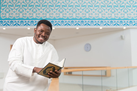 Portrait Of A African Muslim Man Making Traditional Prayer To God While Wearing A Traditional Cap Dishdashaの写真素材