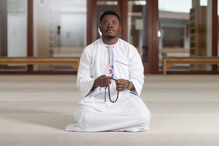 African Muslim Man Making Traditional Prayer To God While Wearing A Traditional Cap Dishdashaの写真素材