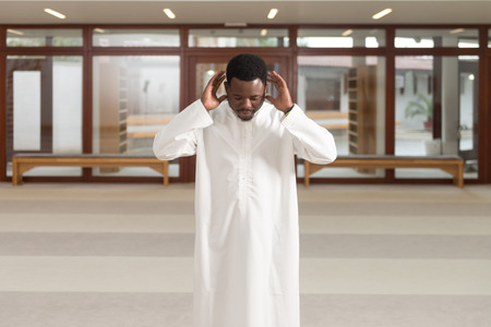 African Muslim Man Making Traditional Prayer To God While Wearing A Traditional Cap Dishdashaの写真素材