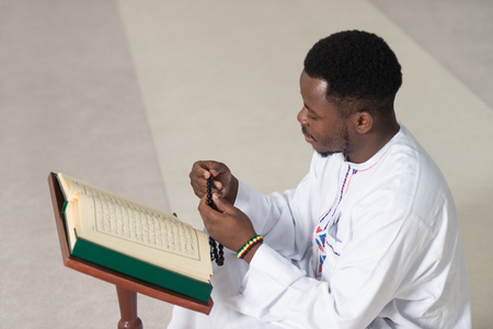Black African Muslim Man Reading Holy Islamic Book Koranの写真素材