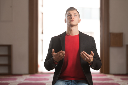 Attractive Blond Man Making Traditional Prayer to God Allah in the Mosqueの写真素材