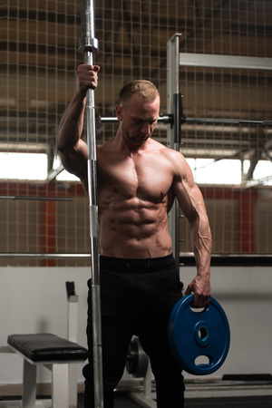 Portrait Of A Physically Fit Man Posing In Modern Fitness Center Gymの写真素材