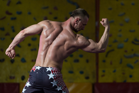 Portrait Of A Young Physically Fit Man Showing His Well Trained Body - Muscular Athletic Bodybuilder Fitness Model Posing After Exercisesの写真素材