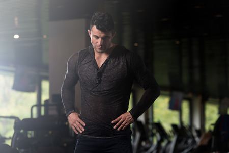 Handsome Young Man Standing Strong in  Black T-shirt Long Sleevs and Flexing Muscles - Muscular Athletic Bodybuilder Fitness Model Posing After Exercisesの写真素材