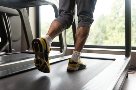 Close-up Of Male Legs Running On Treadmill - Blurred Motionの写真素材