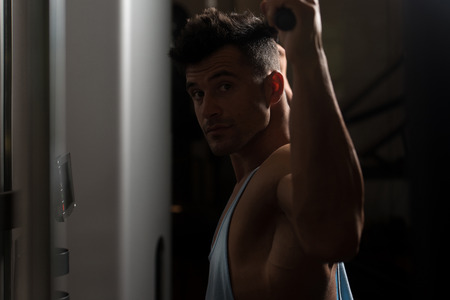 Bodybuilder Doing Heavy Weight Exercise For Back On Machineの写真素材