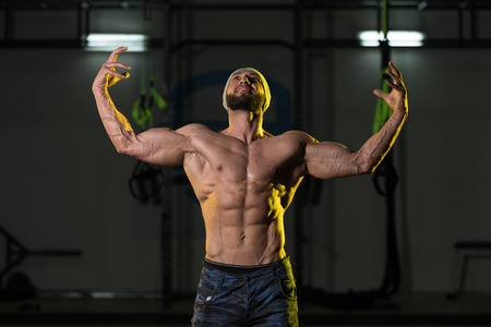 Portrait Of A Young Physically Fit Man Showing His Well Trained Body - Muscular Athletic Bodybuilder Fitness Model Posing After Exercisesの写真素材