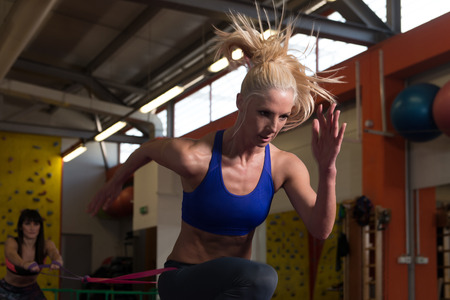 Young Couple Train Together With Resistance Bands A Leg Exercise In A Health And Fitness Conceptの写真素材