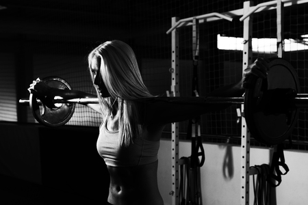 Fitness Woman Performing Barbell Squats - One Of The Best Bodybuilding Exercise For Legsの写真素材