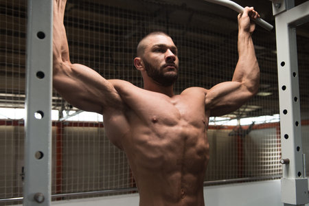 Man Athlete Doing Pull Ups - Chin-Ups In The Gym