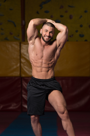 Portrait Of A Young Physically Fit Man Showing His Well Trained Body - Muscular Athletic Bodybuilder Fitness Model Posing After Exercisesの写真素材