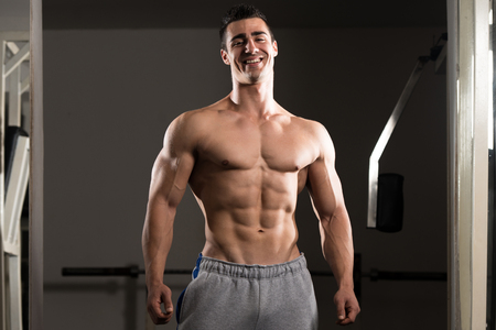 Portrait Of A Young Physically Fit Man Showing His Well Trained Body - Muscular Athletic Bodybuilder Fitness Model Posing After Exercisesの写真素材