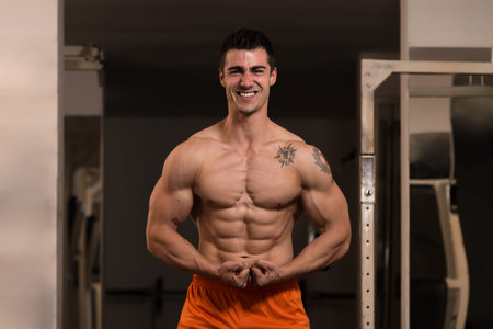 Bodybuilder Posing In Different Poses Demonstrating Their Muscles - Male Showing Muscles Straining -...