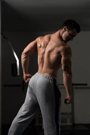 Bodybuilder Posing In Different Poses Demonstrating Their Muscles - Male Showing Muscles Straining - Beautiful Muscular Body Athleteの写真素材