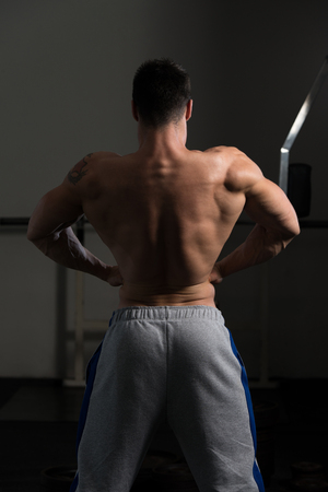 Portrait Of A Young Physically Fit Man Showing His Well Trained Body - Muscular Athletic Bodybuilder Fitness Model Posing After Exercisesの写真素材