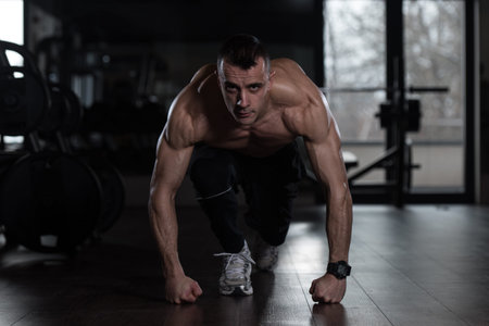 Strong Muscular Men Kneeling On The Floor - Almost Like Sprinter Starting Position