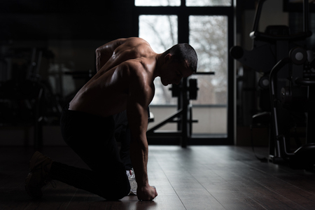 Handsome Man Standing Strong In A Modern Gym And Flexing Muscles - Muscular Athletic Bodybuilder Fitness Model Posing After Exercisesの写真素材