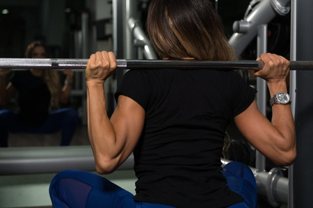 Woman Working Out Legs With Barbell In A Gym - Squat Exerciseの写真素材