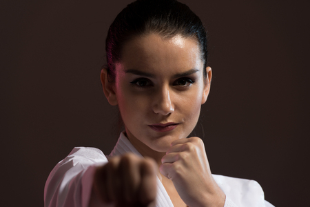 Young Woman Practicing Her Karate Moves - White Kimono - Black Beltの写真素材