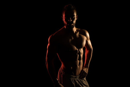 Silhouette Muscular Model Posing On Isolated On Black Backgroundの写真素材