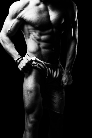 Young Athlete Flexing Leg Muscles - Isolate On Black Blackground - Copy Spaceの写真素材