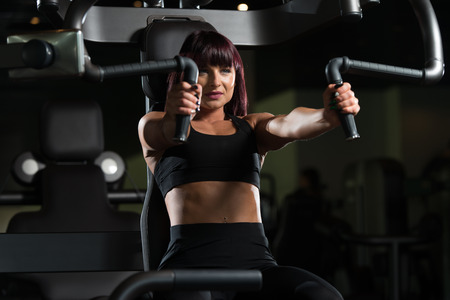 Fitness Woman Doing Heavy Weight Exercise For Chest On Machine With Cable In The Gymの写真素材