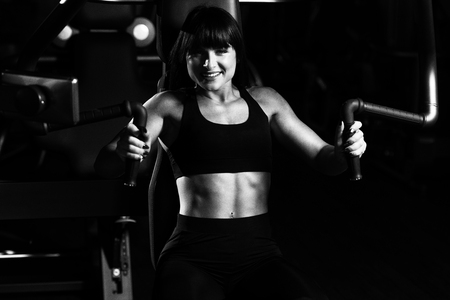 Fitness Woman Doing Heavy Weight Exercise For Chest On Machine With Cable In The Gymの写真素材