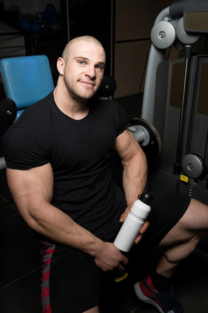 Muscular Man Resting After Exercise And Drinking From Shakerの写真素材