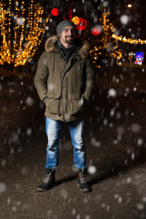 Having Fun at a Christmas Fairy - Young Cheerful Man Dressed Warm Is Standing In Holiday Marketの写真素材