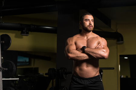 Portrait Of A Young Physically Fit Man Showing His Well Trained Body - Muscular Athletic Bodybuilder Fitness Model Posing After Exercisesの写真素材