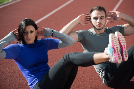 Attractive Couple Exercising in City Park Area - Training and Exercising for Endurance - Fitness...