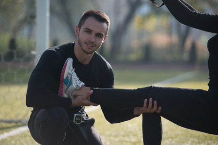 Attractive Couple Doing Crossfit With Trx Fitness Straps in City Park Area - Training and Exercising for Endurance - Healthy Lifestyle Concept Outdoorの写真素材