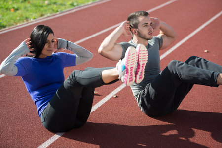 Attractive Couple Exercising in City Park Area - Training and Exercising for Endurance - Fitness...
