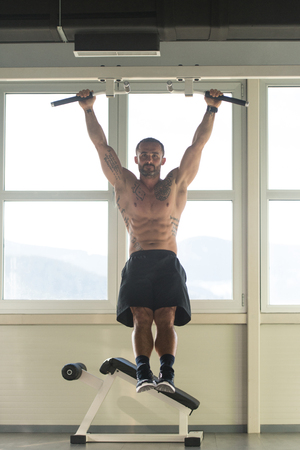Athlete Performing Hanging Leg Raises Exercise - One Of The Most Effective Ab Exercisesの写真素材