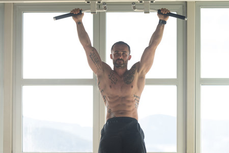 Athlete Performing Hanging Leg Raises Exercise - One Of The Most Effective Ab Exercises