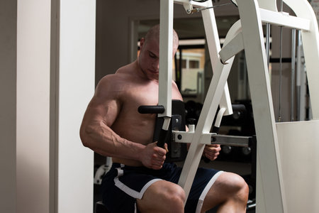 Male Bodybuilder Doing Heavy Weight Exercise For Back In Gym