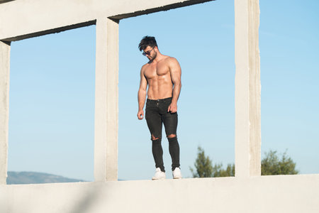 Handsome Man Standing Strong and Posing at Outdoors Wearing Black Jeans - Background of Skyの写真素材