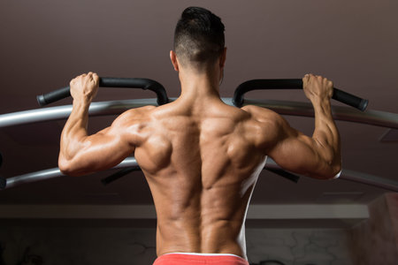 Man Athlete Doing Pull Ups - Chin-Ups In The Gym