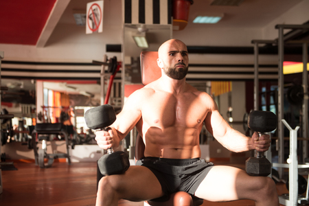 Athlete Working Out Biceps In A Gym - Dumbbell Concentration Curlsの写真素材