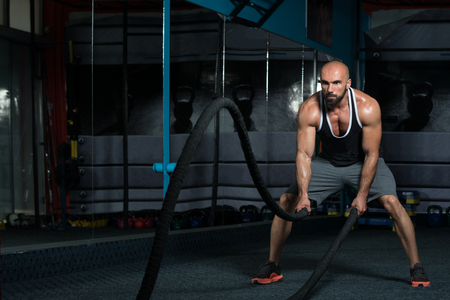 Man Battling Ropes At Gym Workout Exerciseの写真素材