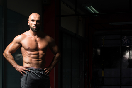 Portrait Of A Young Physically Fit Man Showing His Well Trained Body - Muscular Athletic Bodybuilder Fitness Model Posing After Exercisesの写真素材
