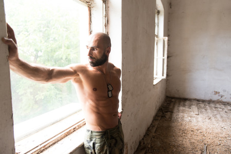Portrait of a Physically Fit Man Showing His Well Trained Body - Muscular Athletic Bodybuilder Fitness Man Posing After Exercises Inside Shelterの写真素材